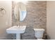 Updated half bathroom with pedestal sink and stone tile feature wall at 1912 E Gemini Pl, Chandler, AZ 85249