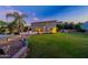 Evening view of backyard with home, lawn, and garden accents at 1912 E Gemini Pl, Chandler, AZ 85249