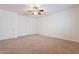 Spacious bedroom with neutral carpeting and ceiling fan at 9947 W Wizard Ln, Peoria, AZ 85383