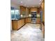 Modern kitchen with light wood cabinets, stainless steel appliances, and tile flooring at 3114 E Hazelwood St, Phoenix, AZ 85016