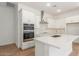 Modern kitchen with white cabinets, stainless steel appliances, and island at 7010 E Drygulch Rd, San Tan Valley, AZ 85143