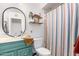 Bathroom with teal vanity, shower, and striped curtain at 3017 W Hearn Rd, Phoenix, AZ 85053