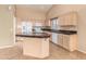 Kitchen with island, granite countertops, and light wood cabinets at 14766 W Piccadilly Rd, Goodyear, AZ 85395
