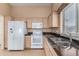 Bright kitchen with granite countertops and white appliances at 14766 W Piccadilly Rd, Goodyear, AZ 85395
