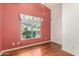 Bedroom with wood flooring, window with window treatment, and painted walls at 14766 W Piccadilly Rd, Goodyear, AZ 85395