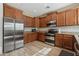 Modern kitchen with stainless steel appliances and wood cabinets at 391 W Dragon Tree Ave, Queen Creek, AZ 85140