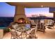 Outdoor patio with fireplace and seating area, offering scenic sunset views at 9215 E Red Lawrence Dr, Scottsdale, AZ 85262