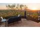 Stone patio with seating area offering stunning sunset views and mountain backdrop at 9215 E Red Lawrence Dr, Scottsdale, AZ 85262