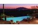 Stunning nighttime view of a luxurious pool and mountain scenery at 9215 E Red Lawrence Dr, Scottsdale, AZ 85262