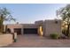 Two-car garage with dark wood doors and desert landscaping at 9215 E Red Lawrence Dr, Scottsdale, AZ 85262