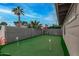 Putting green in backyard with surrounding block wall and palm trees at 8325 E Crestwood Way, Scottsdale, AZ 85250