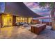 Modern patio with fire pit and comfortable seating area at dusk at 8325 E Crestwood Way, Scottsdale, AZ 85250