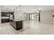 Open concept kitchen with an island, dark cabinets, and a view into living room at 19034 W Yucatan Dr, Surprise, AZ 85388