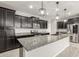 Modern kitchen with dark cabinetry, granite counters, and stainless steel appliances at 19034 W Yucatan Dr, Surprise, AZ 85388