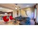 Living room with a sectional sofa, red accent chairs, and a glass-top coffee table at 42715 N Courage Trl, Anthem, AZ 85086