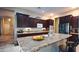 Kitchen features granite countertops, dark wood cabinets and stainless steel appliances at 42715 N Courage Trl, Anthem, AZ 85086