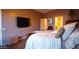 Elegant bedroom with a large bed, mounted TV, and hardwood floors at 42715 N Courage Trl, Anthem, AZ 85086