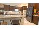 Island kitchen with granite countertops, dark wood cabinets, and stainless steel appliances at 42715 N Courage Trl, Anthem, AZ 85086