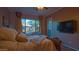 Spacious bedroom with large window, plush bedding, and mounted TV at 42715 N Courage Trl, Anthem, AZ 85086