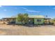 Green house with covered porch and desert landscaping at 48008 N 520Th Ave, Aguila, AZ 85320