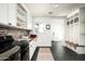 Laundry room with white cabinets, wood countertop, and black appliances at 88 N Country Club Dr, Phoenix, AZ 85014