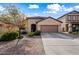 Tan house with two-car garage and landscaping at 1095 W Desert Valley Dr, San Tan Valley, AZ 85143