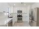 Modern kitchen with white cabinets, stainless steel appliances, and quartz countertops at 5714 N 19Th Dr, Phoenix, AZ 85015