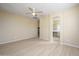 Large bedroom with ceiling fan, wood-look flooring, and access to bathroom at 12101 W Dove Wing Way, Peoria, AZ 85383