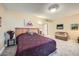 Primary bedroom with a king-size bed and a relaxing sitting area at 12946 W Ashwood Dr, Sun City West, AZ 85375