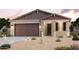 One-story home with brown-toned exterior, two-car garage, and desert landscaping at 40010 W Bravo Dr, Maricopa, AZ 85138
