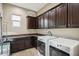 Laundry room with washer, dryer, and dark wood cabinets at 27016 N 14Th Ln, Phoenix, AZ 85085