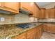 Kitchen with granite countertops, gas cooktop, and wood cabinets at 13232 W Los Bancos Dr, Sun City West, AZ 85375
