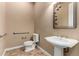 Bathroom with pedestal sink, toilet and grab bars at 13232 W Los Bancos Dr, Sun City West, AZ 85375