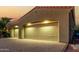 Two-car garage with a well-lit driveway and desert landscaping at 13232 W Los Bancos Dr, Sun City West, AZ 85375