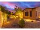 Landscaped backyard with lighting, mature trees, and a patio area at 28694 N 127Th Ln, Peoria, AZ 85383
