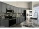 Modern kitchen with stainless steel appliances and granite countertops at 27824 N 256Th Ave, Wittmann, AZ 85361