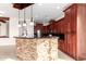 Kitchen island with stone facade and dark wood cabinets at 568 N Falcon Dr, Gilbert, AZ 85234