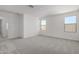 Well-lit bedroom with carpet flooring and access to hallway at 7499 E Sweet Honey Ln, San Tan Valley, AZ 85143