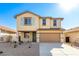 Two-story house with tan exterior, light green shutters, and a two-car garage at 7499 E Sweet Honey Ln, San Tan Valley, AZ 85143