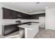 Modern kitchen with dark cabinets and a large island at 7499 E Sweet Honey Ln, San Tan Valley, AZ 85143