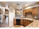 Kitchen features granite countertops, wood cabinets, and a view of the living area at 9220 E Whitethorn Cir, Scottsdale, AZ 85266