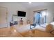Living room with hardwood floors, a large TV, and balcony access at 2025 E Campbell Ave # 330, Phoenix, AZ 85016