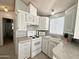 Open kitchen with white cabinets, view into adjacent living area at 225 S Motherlode Dr, Apache Junction, AZ 85119