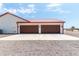 Three-car garage with a metal roof and double doors at 5604 S 225Th Ave, Buckeye, AZ 85326
