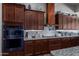 Modern kitchen features dark wood cabinets and stainless steel appliances at 5604 S 225Th Ave, Buckeye, AZ 85326
