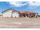 Single story home with red metal roof, covered porch, and gravel driveway at 5604 S 225Th Ave, Buckeye, AZ 85326