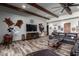 Spacious living room with wood beams, leather furniture, and a large TV at 5604 S 225Th Ave, Buckeye, AZ 85326