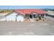 Single story home with red metal roof, landscaping, and large driveway at 5604 S 225Th Ave, Buckeye, AZ 85326