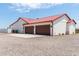 Three-car garage with metal roof, stucco exterior and double doors at 5604 S 225Th Ave, Buckeye, AZ 85326