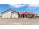 Single story home with red metal roof, covered porch, and gravel driveway at 5604 S 225Th Ave, Buckeye, AZ 85326